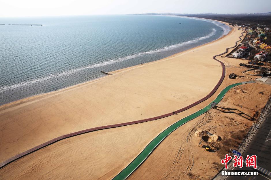 3月13日，秦皇島萬(wàn)米臨海沙灘木棧道。據了解，該木棧道全長(cháng)約4200米，與北戴河區原有的7500米木棧道對接后全線(xiàn)總長(cháng)度1.17萬(wàn)米，整個(gè)木棧道東起秦皇島體育基地游船碼頭，西至北戴河濕地公園，呈波浪形蜿蜒10.4公里海岸線(xiàn)。 中新社發(fā) 曹建雄 攝 CNSPHOTO