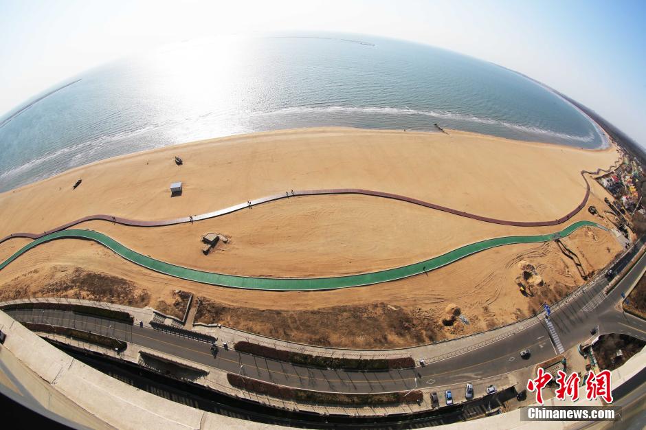 3月13日，秦皇島萬(wàn)米臨海沙灘木棧道。據了解，該木棧道全長(cháng)約4200米，與北戴河區原有的7500米木棧道對接后全線(xiàn)總長(cháng)度1.17萬(wàn)米，整個(gè)木棧道東起秦皇島體育基地游船碼頭，西至北戴河濕地公園，呈波浪形蜿蜒10.4公里海岸線(xiàn)。 中新社發(fā) 曹建雄 攝 CNSPHOTO